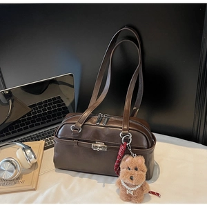 Detail of dark brown retro underarm bag with metal twist-lock and pearl teddy charm