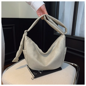 Detailed close-up of cream white hobo bag showing textured leather and wide shoulder strap