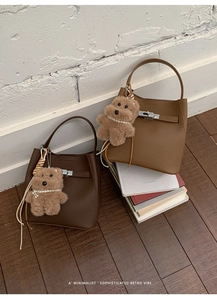Close-up of retro bucket bags with pebble leather texture and metallic lock buckle detail