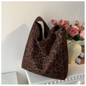 Detailed close-up of dark brown leopard print tote bag texture on a white fireplace