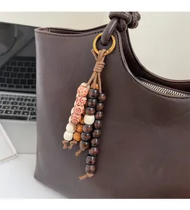 Macro detail of dark brown faux leather tote bag texture with colorful wooden bead tassel