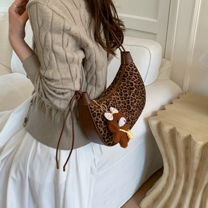 Leopard print crescent shoulder bag with brown leather trim and cute bear charm