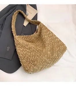 Detailed view of brown plush lamb wool shoulder bag on grey suit and white cloth