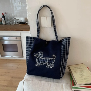 Détail d'un sac cabas en toile avec motifs à carreaux et broderie de teckel stylisé