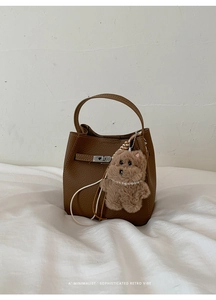 Detail of retro brown bucket bag with litchi grain leather and silver metal buckle
