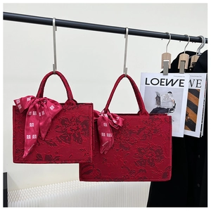 Détail macro de l'ensemble de sacs de mariée rouges avec jacquard pivoine et ruban xi