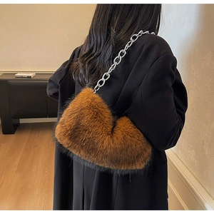 Sac sous le bras en fausse fourrure marron avec chaîne en métal argenté sur un modèle