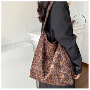 Detailed side view of a large leopard print tote bag styled with a black blazer
