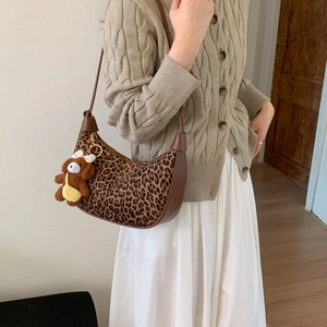 Detail shot of leopard print hobo bag with faux fur finish and cute bear charm