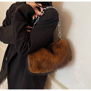 Détail de la texture fausse fourrure marron et chaîne argentée d'un sac à main femme