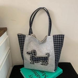 Détail du sac cabas en toile avec broderie teckel et design patchwork en tricot gris
