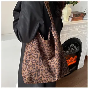 Large leopard print tote bag shown on shoulder in a cozy home setting with vintage decor
