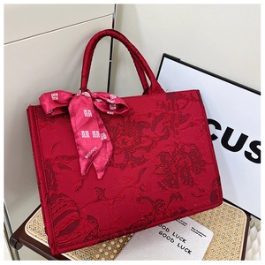 Gros plan du sac de mariée rouge avec broderies florales et poignée en foulard de soie