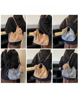 Detail of vintage soft leather hobo bag with teddy charm and adjustable dual straps