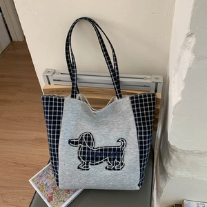Détail du sac cabas en toile avec broderie de teckel et tissu gris texturé