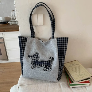 Détail du sac fourre-tout en toile avec écusson teckel en tricot et carreaux bleus
