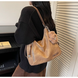 Close-up of a large vintage camel tote bag with matte texture and decorative zipper detail