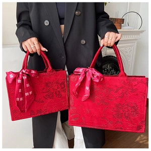 Détail du sac de mariage rouge en jacquard avec texture florale et ruban du caractère Xi