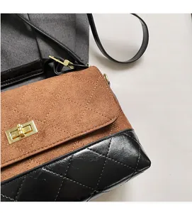 Detail der braunen Wildleder- und schwarzen gesteppten Ledertasche mit Goldschloss