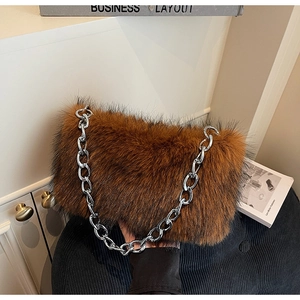 Gros plan du sac en fausse fourrure caramel avec chaîne en métal argenté sur fond sombre