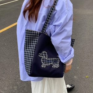 Détail d'un grand sac cabas en toile avec broderie teckel et bandoulière à carreaux