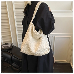 Close-up of white plush fleece tote bag on model showing soft texture and hobo design