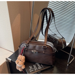 Detailed mirror view showing dark brown leather shoulder bag with plush puppy keychain