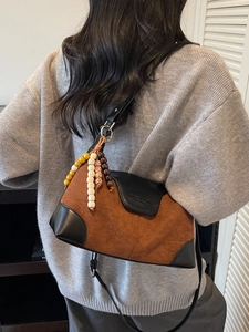 Brown suede dumpling bag with black leather patchwork and colorful beaded charms