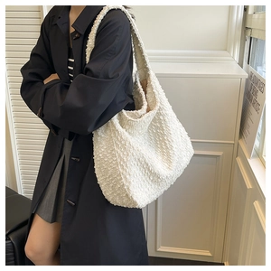 Detail of white plush faux fur tote bag showing soft texture and wide shoulder strap