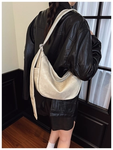 Detail of off-white oversized crescent bag showing supple leather texture and embossed logo