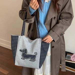 Détail du sac cabas en toile avec broderie de chien sur tissu à carreaux d'automne