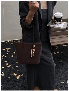 Dettaglio borsa tote vintage in finta pelle scamosciata marrone scuro con ciondolo