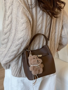 Dark brown leather bucket bag with silver hardware and a cute plush dog pendant charm