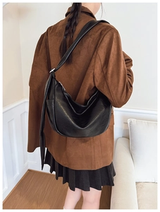 Detail shot of the black PU crescent bag showing vintage texture and wide shoulder strap