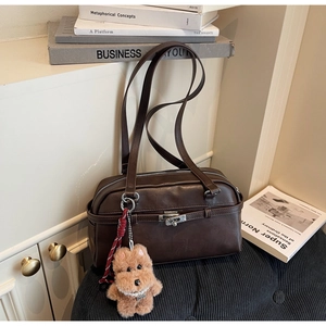 Detail of vintage brown shoulder bag with silver mechanical twist lock and plush puppy charm