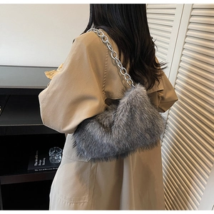 Détail du sac à bandoulière en fausse fourrure grise avec chaîne argentée sur modèle