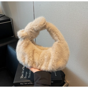Dettaglio di una borsa in pelliccia sintetica beige con elegante manico a nodo
