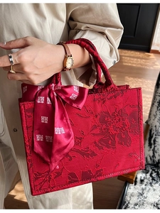 Sac à main de mariage rouge avec texture jacquard florale et nœud en soie sur la poignée