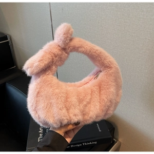 Dettaglio della borsa rosa in finta pelliccia con manico a nodo e morbida texture pelosa