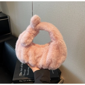 Dettaglio della borsa in peluche rosa con trama a coste e nodo decorativo sul manico