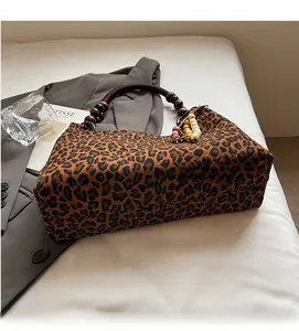 Detailaufnahme der Leoparden-Einkaufstasche mit dunklen Holzperlengriffen und weichem Plüsch