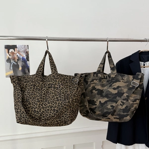 Detail showing leopard print and camo canvas tote bags with adjustable straps