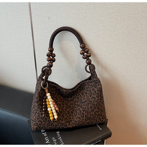 Detail der Handtasche mit Leopardenmuster, Holzperlengriffen und Perlen-Quasten-Akzenten