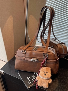 Vintage brown leather Boston shoulder bag with dual zippers and plush bear charm