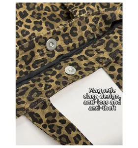 Detail of leopard print canvas tote bag featuring a secure magnetic snap button closure