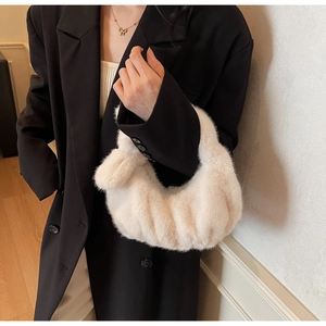 Dettaglio di una borsa in peluche crema con elegante trama a pieghe soffice come una nuvola