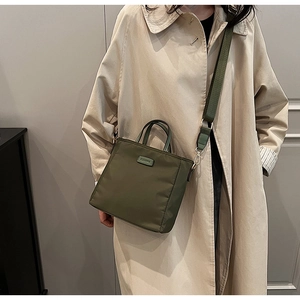 Detail view of army green nylon crossbody tote bag with adjustable shoulder strap and logo