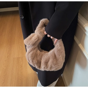 Dettaglio borsa da polso in morbido peluche color cammello con elegante forma a nuvola