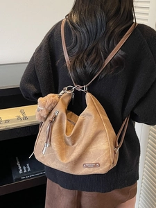 Vintage brown leather multi-way backpack for women with textured finish and pom pom charm