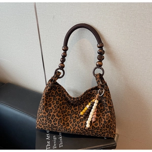 Detail einer Leopard-Tragetasche mit Holzperlengriff und Quasten-Anhänger-Zubehör